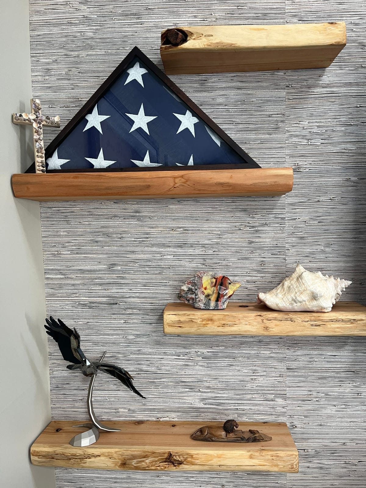 Rustic wood floating shelves holding a folded-flag display case and keepsakes